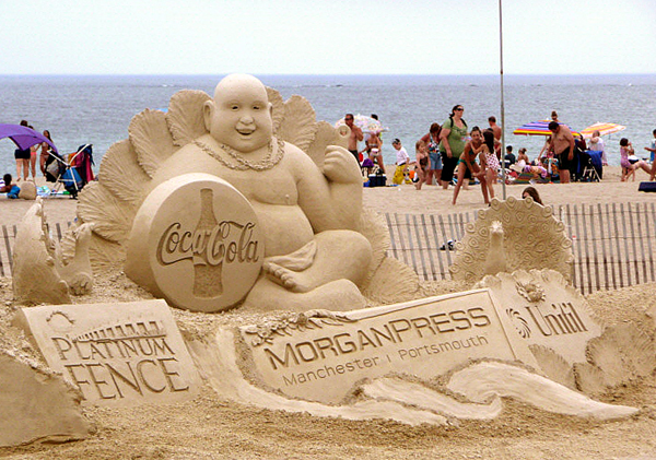 Sculpture Coca-Cola en sable sur une plage