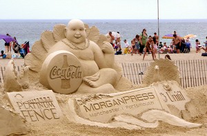 sculpture coca-cola en sable sur une plage